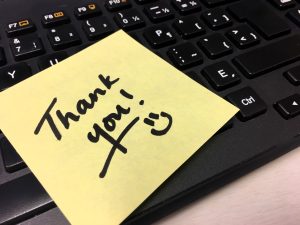 thank you handwritten note on computer keyboard